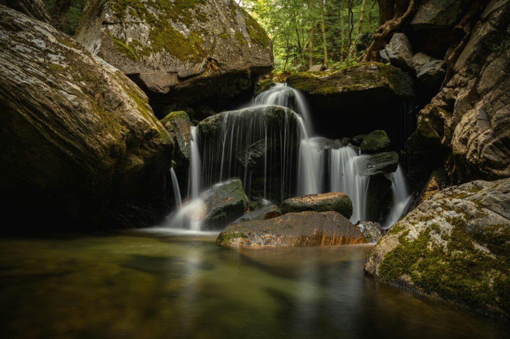 Serene waterfall from rocks symbolizing the art of stillness and cleansing power of nature